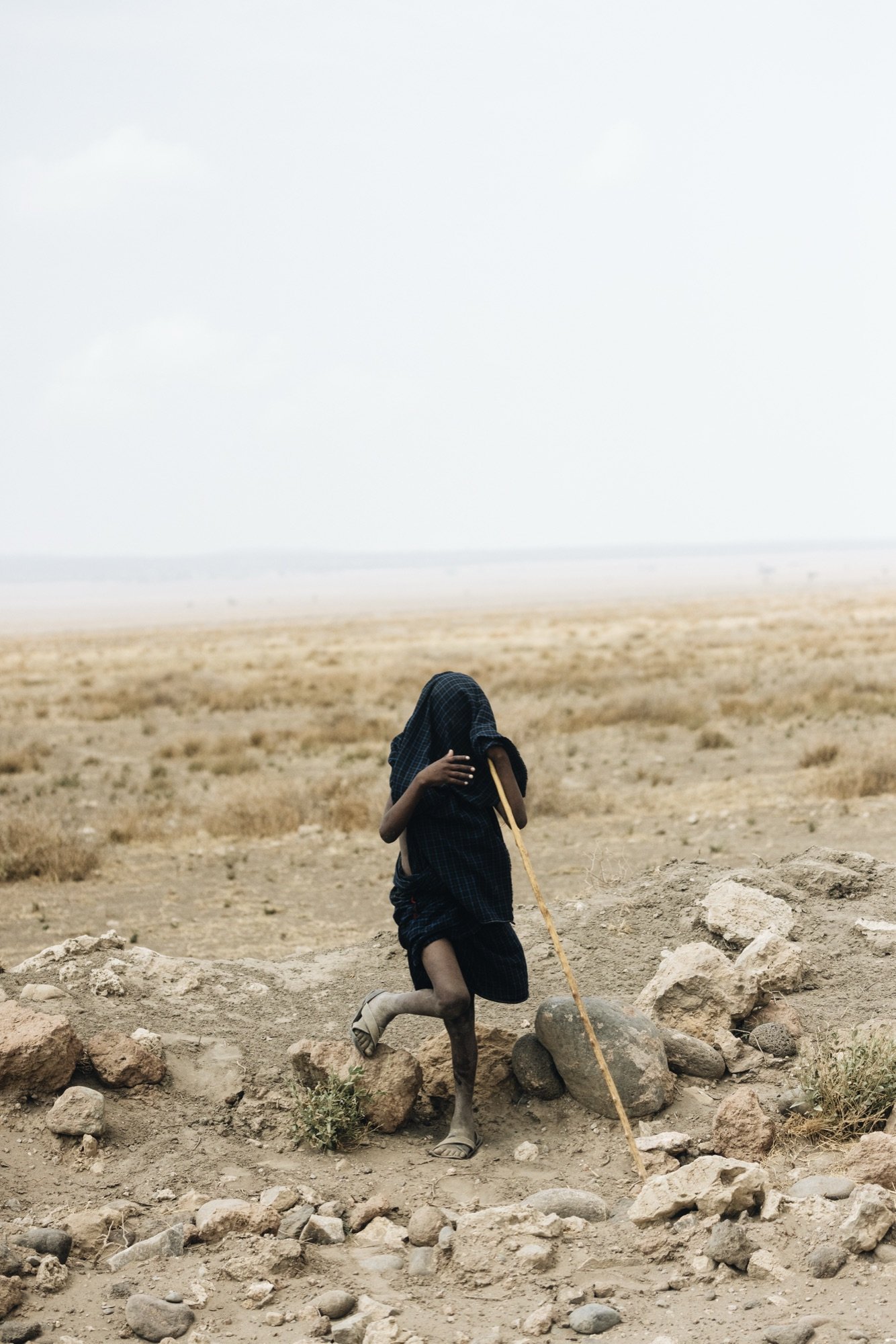 A robed boy with a walking stick