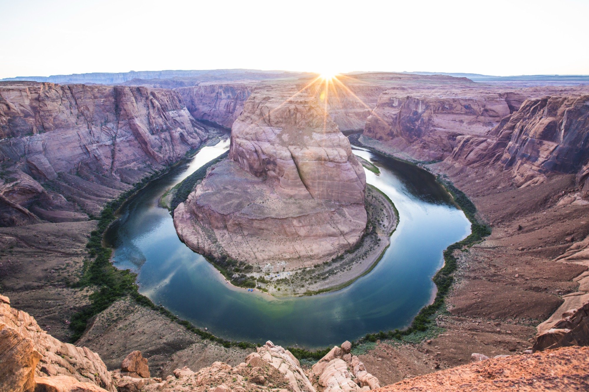 The Colorado River curving around Horseshoe Bend at sunrise