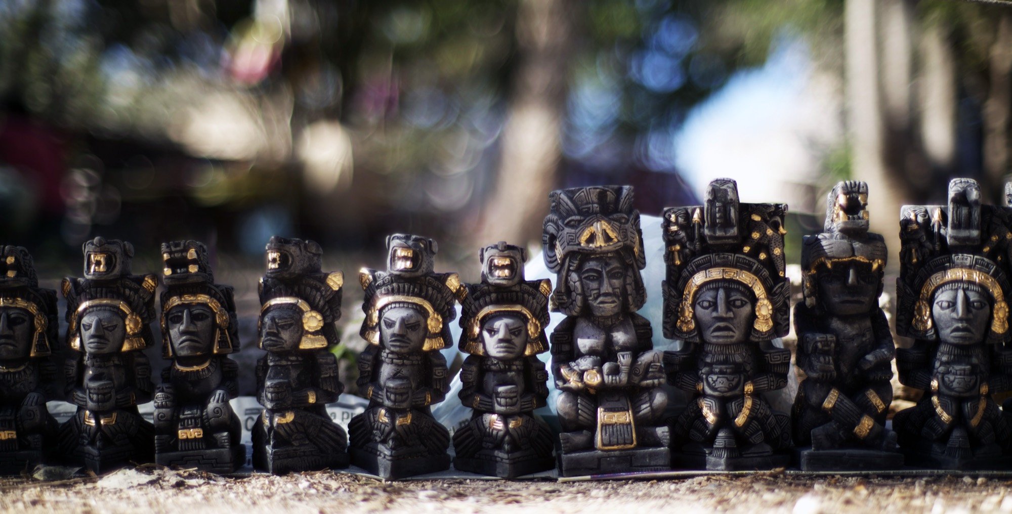 A row of carved idol figurines at a market stall