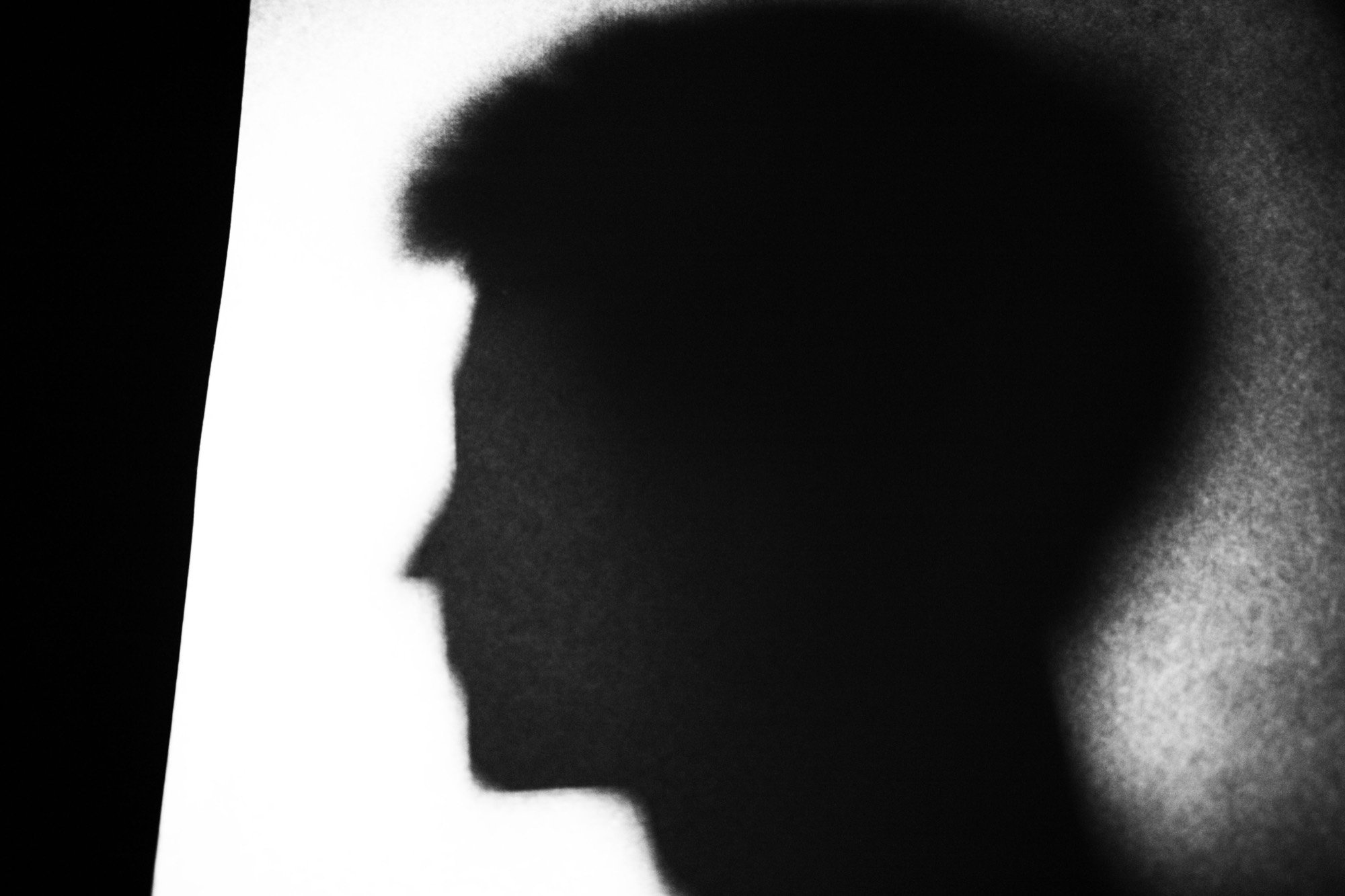 A shadowed profile cast on a bright wall