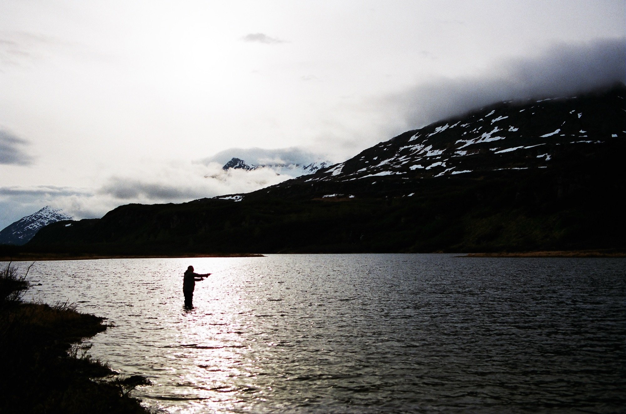 A fly fisher standing in a lake
