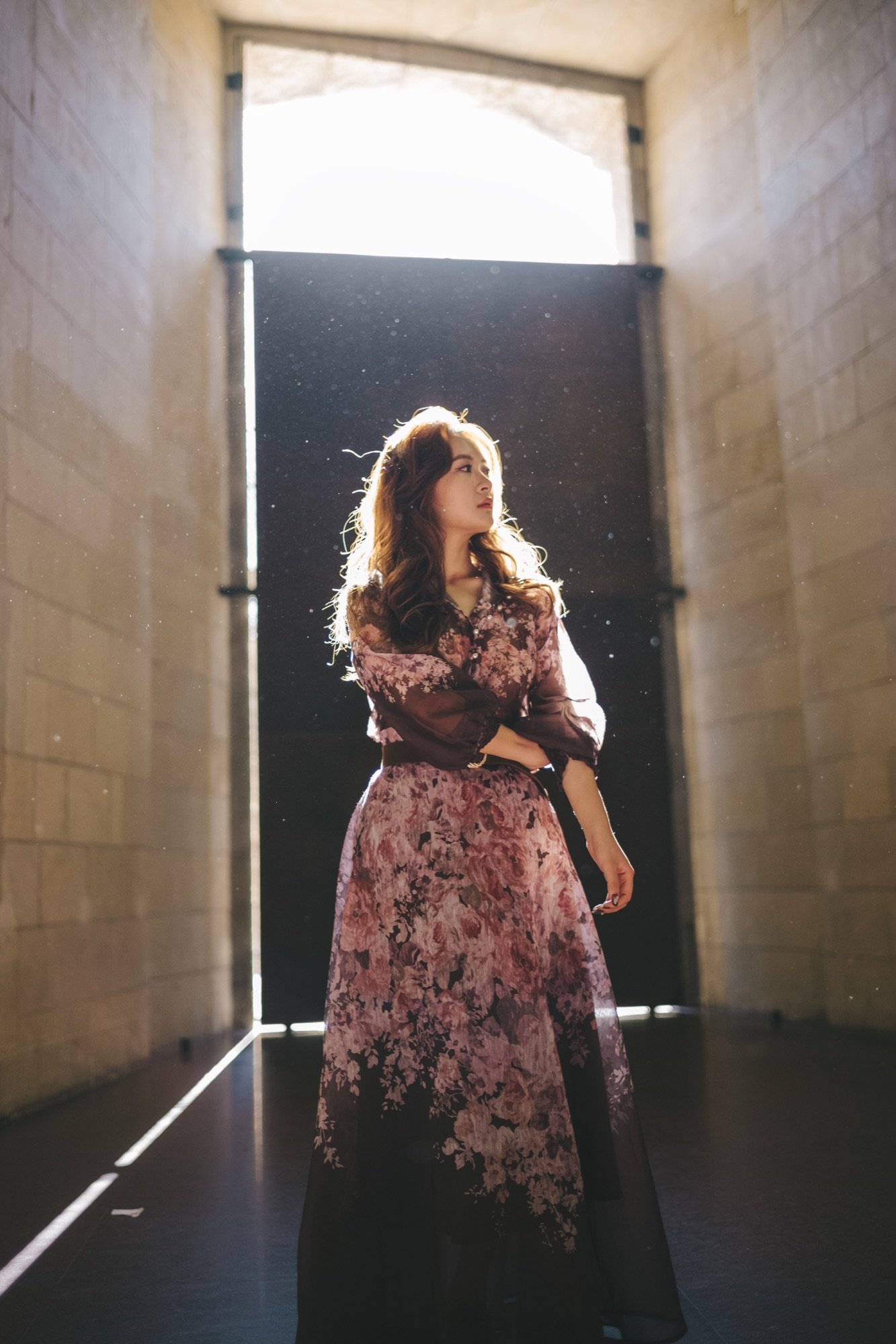 A woman in a floral dress in soft light