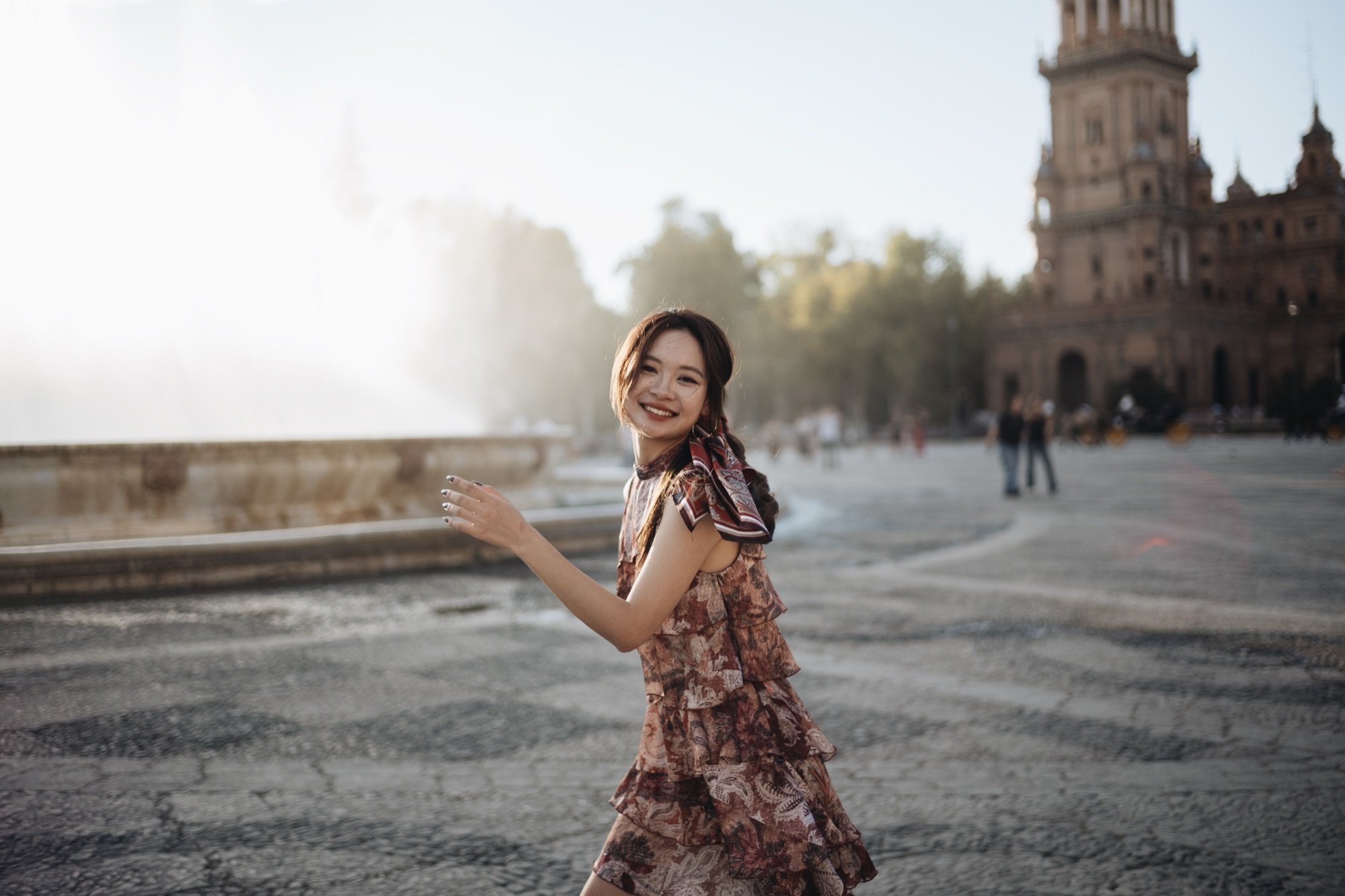 A smiling woman in a plaza