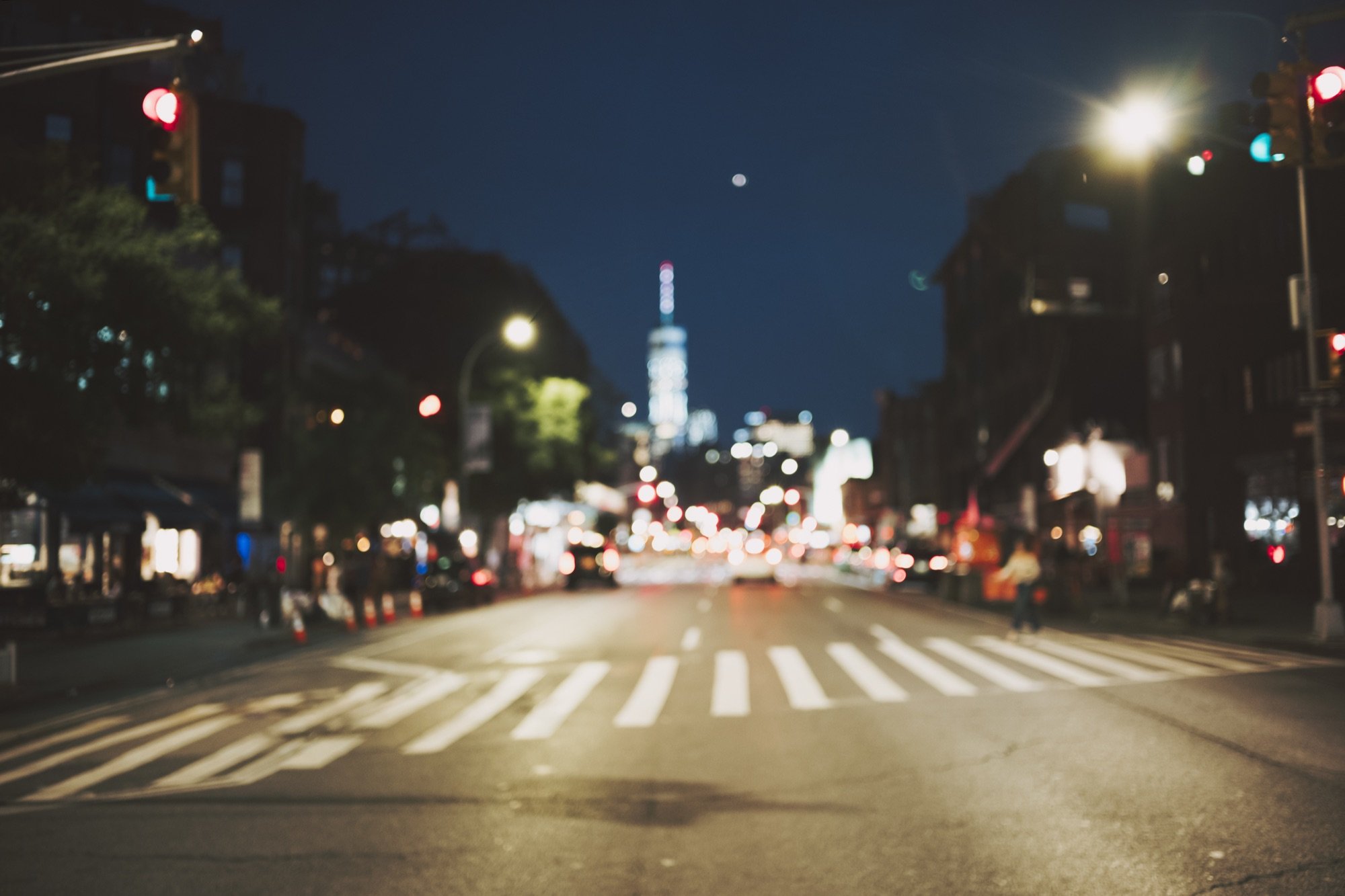 A blurred night crosswalk and skyline