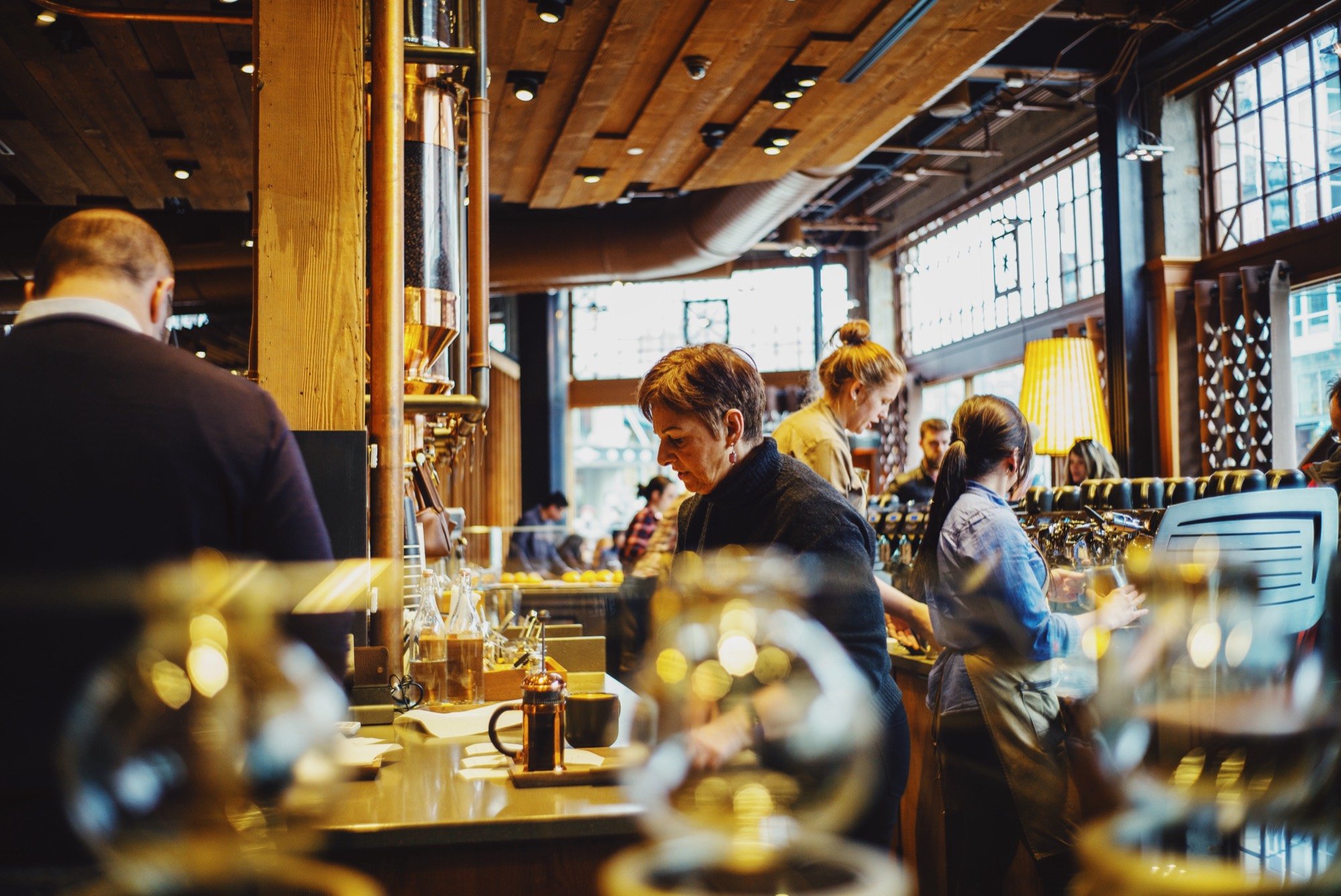 Patrons at a warmly lit wood-paneled bar